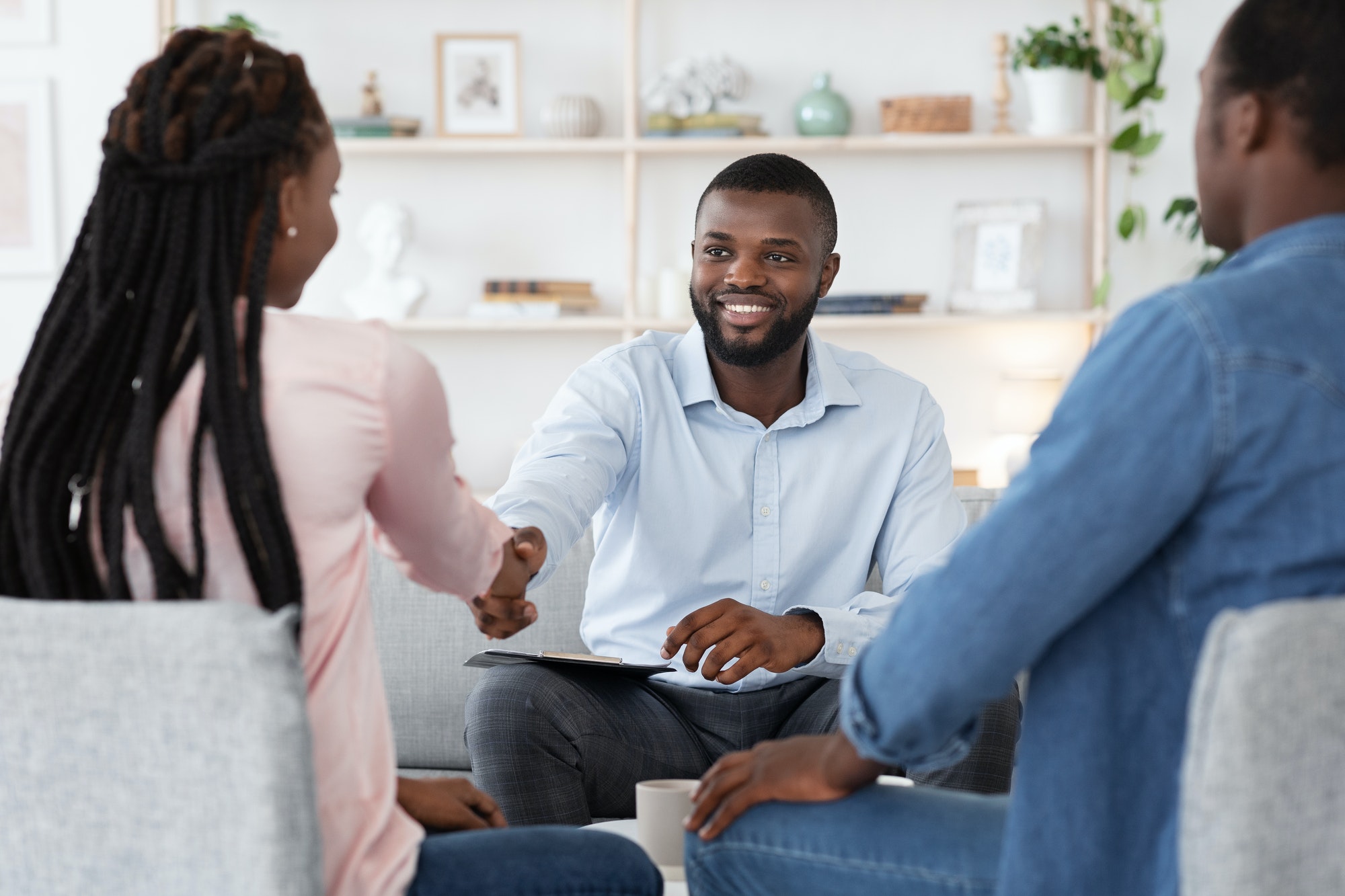 Family Counselor Shaking Hands With Happy Black Couple After Successful Therapy